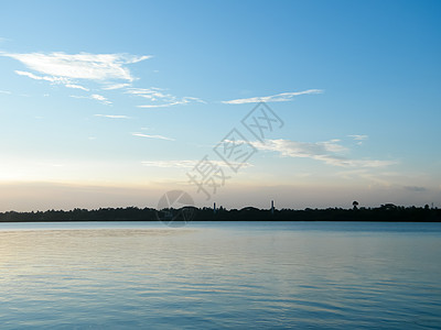 太阳反射器在湖水上的日落天窗反射 风景地平线背景中喜怒无常的蓝调红色和黄色 黄昏到夜间流逝大气的心情 宁静的场景 田园诗般的氛围图片