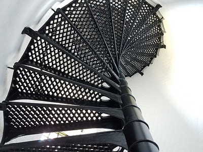 灯塔中的黑铁金属螺层楼梯和白墙白色螺旋脚步建筑栏杆扶手图片