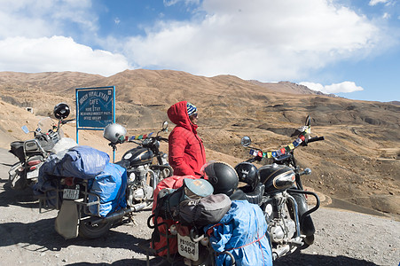 印度妇女旅行者Trikker和Biker站在摩托车旁 远足喜马拉雅山区高山地区外出并探索当地山丘站 冒险旅游队 2019年10月图片