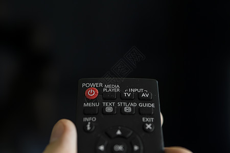 靠近一个拿着遥控器的男人的手想要打开电视并按下遥控器上的按钮 在手特写镜头的遥控成人控制板手指渠道房间房子电影视频安慰技术图片