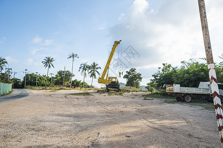 有上升的伸缩臂的黄色汽车起重机在户外 建筑工地上的移动式建筑起重机 起重机在施工大楼下等待工作 重工业机械工程机壳繁荣升降机高度图片