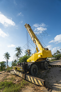 有上升的伸缩臂的黄色汽车起重机在户外 建筑工地上的移动式建筑起重机 起重机在施工大楼下等待工作 重工业蓝色活动地面力量机器柴油机图片