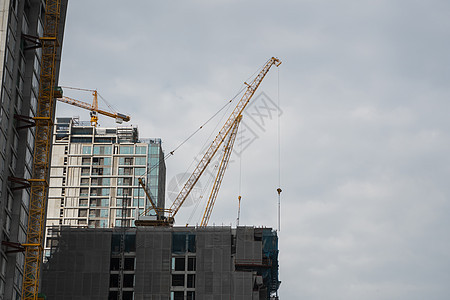 建造一座高楼大楼的建筑工地 用起重机抵挡蓝天工程工作脚手架房地产城市水泥天空公寓建筑学摩天大楼图片