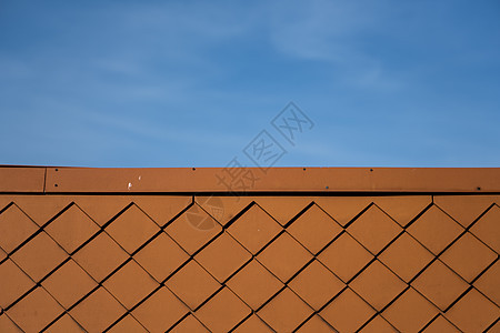 蓝天建筑上的天然橙色屋顶瓦片金属工具住宅钻孔工匠建筑学紧固件陶瓷钻头工作图片