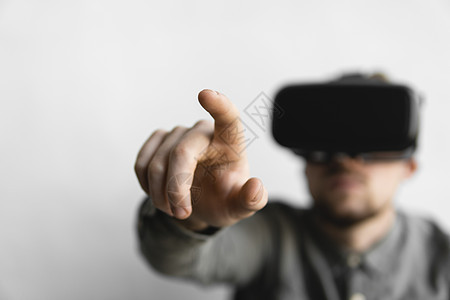 戴着虚拟现实眼镜的留着胡子的年轻男子试图在他所看到的东西前触摸某物或敲击某物 现代技术 未来技术的概念享受商业创新展示活动高科技图片