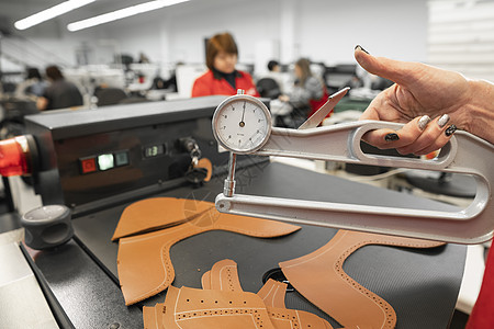 女人的手在天然棕色皮革上使用皮革测厚仪 准备制造箱包 鞋子 服装和配饰的原材料厚度背景色调样品工艺材料手工制造业皮匠动物图片