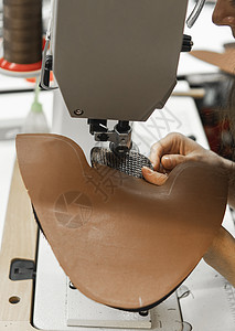 皮革车间的缝纫机在用手处理鞋子的皮革细节 女鞋厂有缝纫机的手接缝裁缝行动缝纫金属机械工人奶牛工厂生产图片