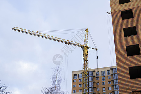 蓝天的起重机和建筑工地 未完工建筑的金属结构施工 塔式起重机用于建造多仓库建筑住宅生长工程工作项目商业技术天空财产公寓图片