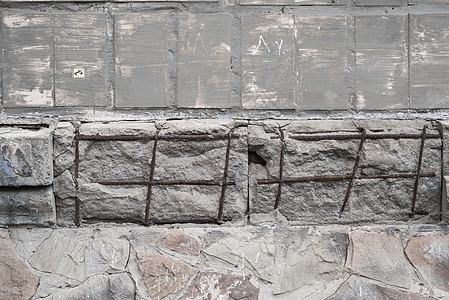 有电枢的破裂的混凝土灰色墙壁 有裂缝和孔洞的脏混凝土质地材料乡村石头建造古董石膏岩石风化建筑建筑学图片