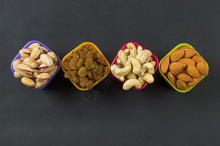 深色背景的健康混合干果和坚果 Almonds Pistachio 腰果 Raisins营养榛子水果诱惑饮食食物花生种子美食甜点图片