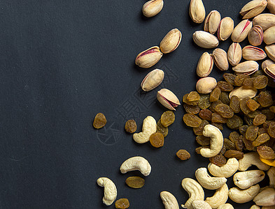 深色背景的健康混合干果和坚果 Almonds Pistachio 腰果 Raisins营养异国饮食榛子浆果小吃种子食物植物水果图片