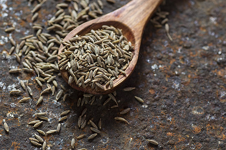 纹理背景上木勺中的孜然种子调味品蔬菜味道草本植物勺子美食维生素营养烹饪食谱图片