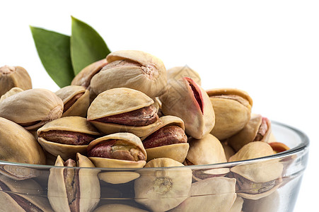 白底玻璃碗里的Pistachios坚果种子盐渍小吃核心团体开心果食物营养叶子图片