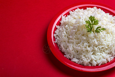 红背景的红色盘子中煮白纯白巴斯马提大米饮食粮食餐厅蒸汽香菜种子营养文化谷物食物背景图片