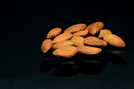 深色背景的杏仁营养核心盐渍坚果饮食维生素团体种子水果食物图片