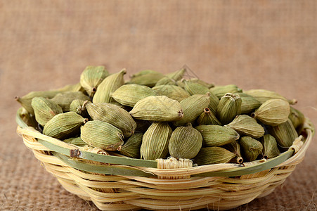 麻布竹篮中的绿卡达莫豆烹饪宏观香料小豆蔻种子调味品食物豆蔻芳香豆荚图片