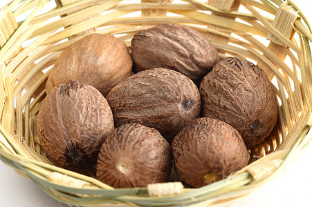 竹篮中的Nutmeg在白色背景上被孤立地面篮子草本植物香味香料宏观香气下巴水果团体图片