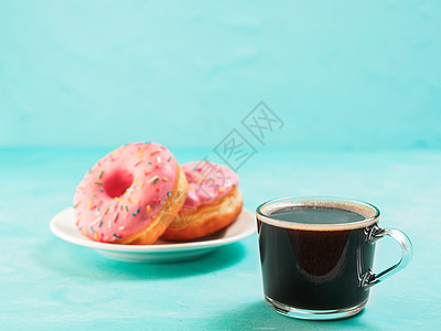 蓝色背景的粉红色甜甜圈 复制空间甜点圆圈小吃玻璃小雨桌子食物面包杯子早餐图片