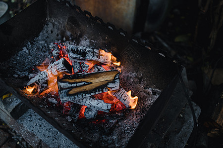 在一个古老的黑暗烧烤木柴中点燃篝火 在黑暗阴沉的色彩中壁炉温度营火火焰辉光日志火盆木头烹饪火花图片