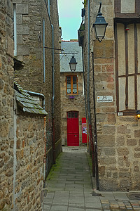 两座传统石块建筑之间狭小的通道 前面有红色入口门图片