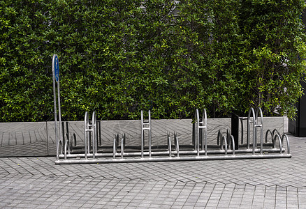 空的不锈钢自行车停放架 墙上有绿色植物的自行车停放标志基础设施旅行框架街道运输公园运动车轮车站车辆图片