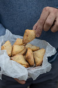 男人用白色纸纸纸的三角形 持有短面包饼干馅饼烹饪羊角小屋身体刀具面包师颗粒状草本植物女性图片