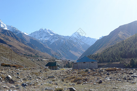 喜马拉雅山脉高山上的山间小屋 为登山者 登山者和徒步旅行者提供庇护所 背景是互锁重叠的小山脊 V 形山谷旅游人行道房子爬坡屋顶花图片