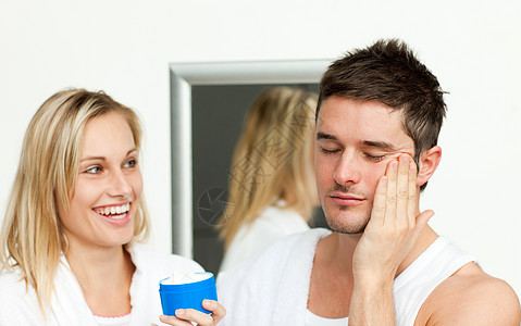 男人和妻子在脸上涂奶油化妆品微笑镜子丈夫恋人浴室家庭女性已婚幸福图片
