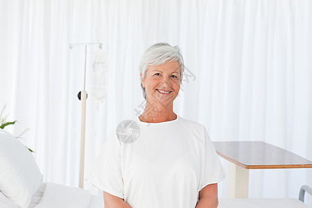 快乐的女人看着医院的摄像机疾病老年治疗退休康复病人白色收容所保健女士图片
