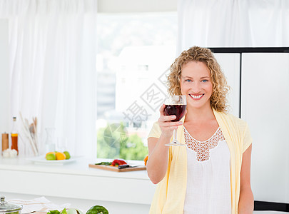 女人拿着酒喝看镜头 看着摄像机女士女孩食谱家庭妻子食物烤箱菜单青年厨房图片