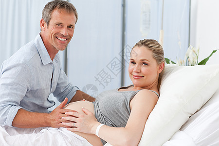可爱的一对情侣在看镜头女性睡衣女孩母亲女士男人病人说谎怀孕母性图片