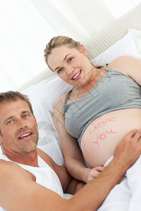 未来父亲抚摸妻子微笑父母女士夫妻母亲母性说谎男人腹部婴儿图片