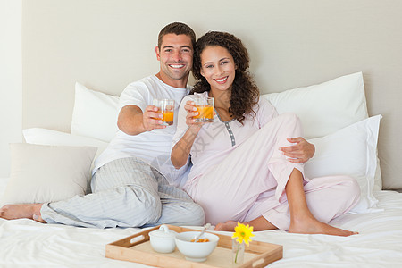 一对夫妇在家里的床上吃早饭感情妻子女性投标睡衣盘子已婚男人幸福女士图片