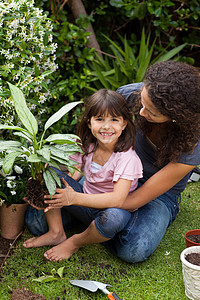 母亲和女儿在花园里工作土壤乐趣帮助家庭女孩妈妈花园培育成人孩子图片