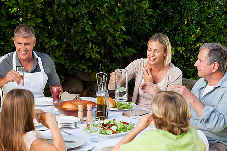可爱的家庭在花园里吃饭黑发沙拉女儿食物孩子们火腿乐趣妻子夫妻女孩图片