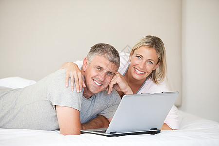 可爱的一对情侣看着镜头网络情人互联网男人女性女孩夫妻电脑女士笔记本图片