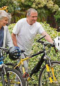 成年夫妇骑着自行车走路男人农村退休男性夫妻享受女性微笑女士公园图片