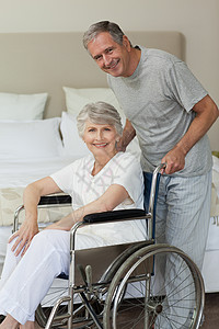 与丈夫一起坐在轮椅上的退休妇女扶手椅椅子车轮截肢女士保险男人保健老年培育图片