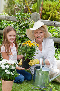 祖母和她孙女外婆在花园里工作孩子土地土壤卷曲乐趣帮助女士女孩植物成人图片