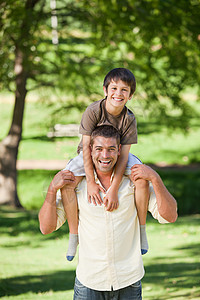 英俊的男人给儿子搭便车乐趣女性幸福男性爬坡孩子生活家庭退休男生图片