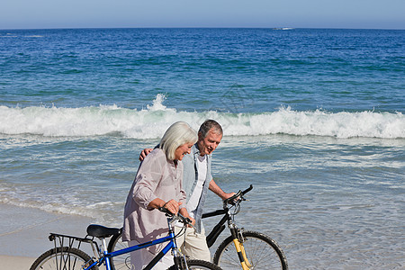 退休夫妇在海滩上骑着自行车妻子闲暇祖母已婚家庭运动婚姻乐趣男人祖父图片