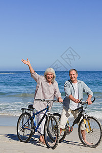 在海滩上骑着自行车的成熟夫妇已婚退休运动家庭妻子乐趣丈夫婚姻闲暇男人图片