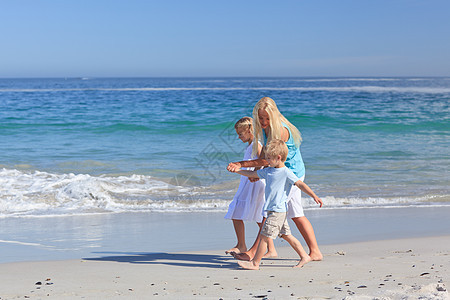 家人在海滩上散步海洋娱乐假期儿子兄弟旅行家庭女士天空支撑图片