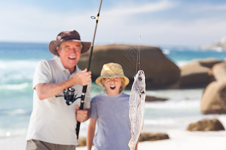 男人和孙子一起钓鱼闲暇孩子支撑祖父乐趣海洋海滨男性海岸男生图片