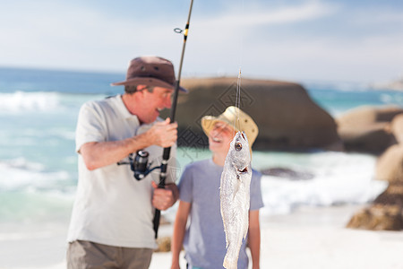 男人和孙子一起钓鱼海滨祖父男性乐趣海岸渔夫男生支撑爱好孩子图片
