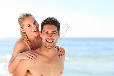 美丽的男人有他的女朋友 一个搭便车海滩幸福男性海洋小猪假期妻子丈夫女士享受图片