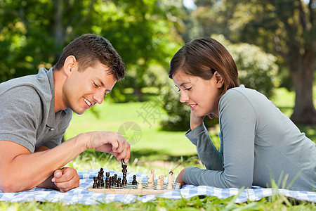 在公园里玩象棋的情侣幸福家庭喜悦男人夫妻微笑生活女性乐趣白色图片