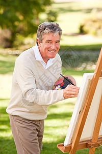 老人在公园里画画画笔艺术家老年调色板男性画架灰色男人退休享受图片