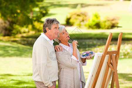公园里的一对老夫妇的绘画艺术家快乐画架享受老年夫妻男人绿色植物刷子闲暇图片