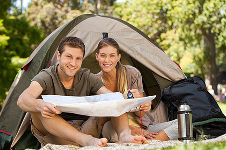 夫妇在公园露营快乐帐篷营地露营者旅游女朋友草原热水瓶冒险望远镜图片